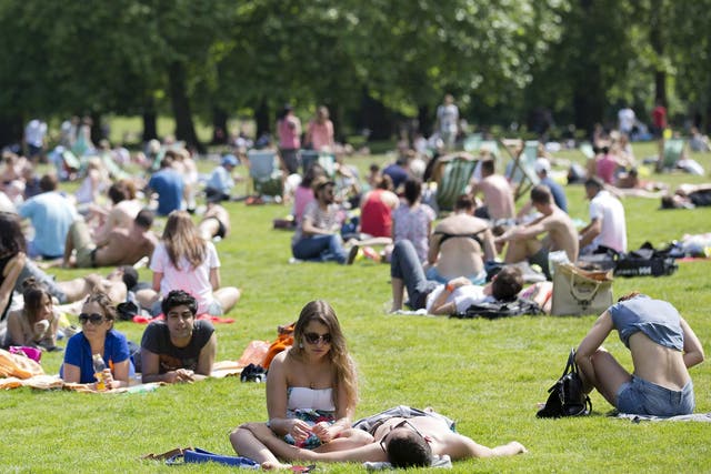 People sunbathe in the summer heat in a park in central London 