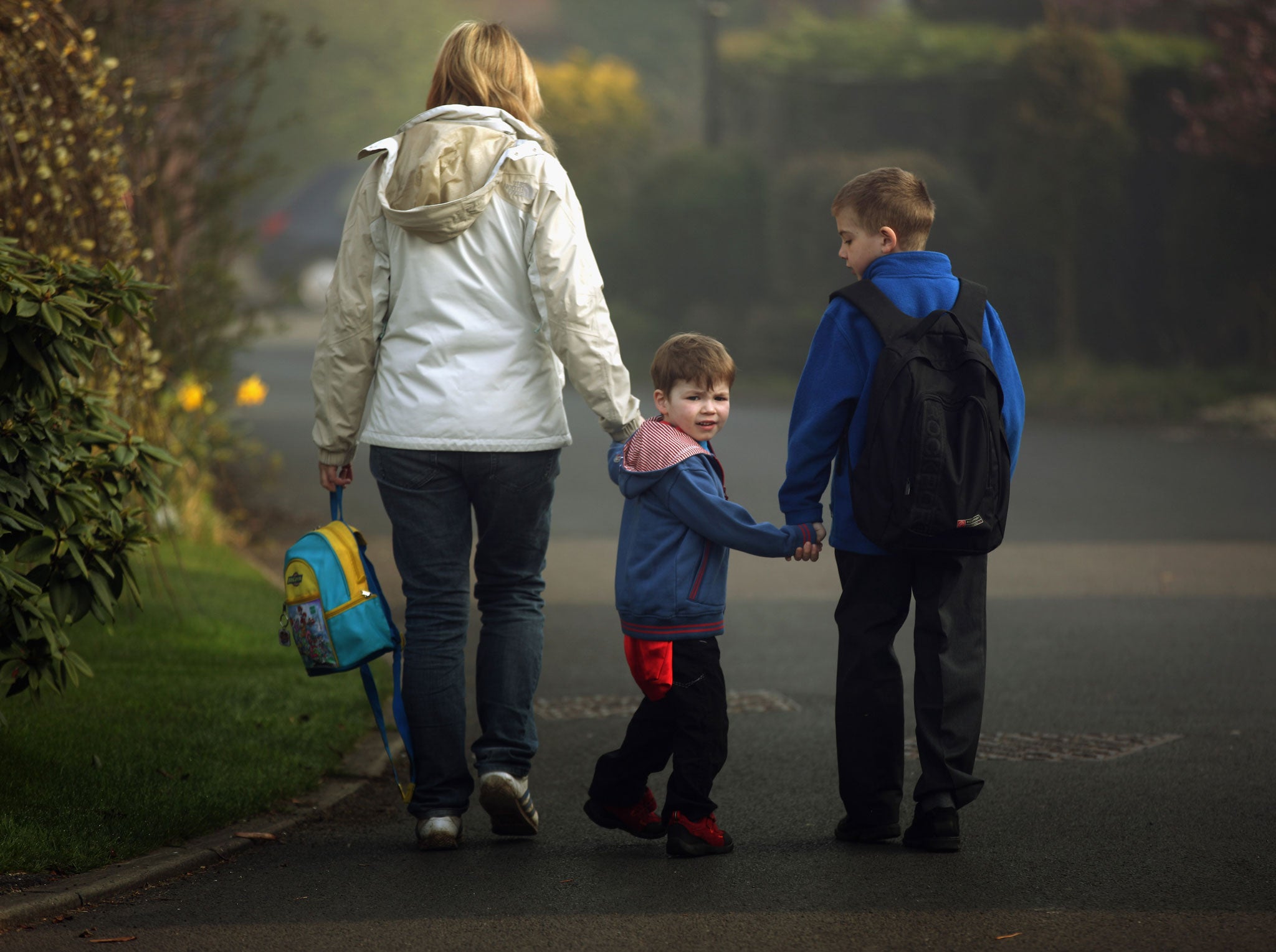 A mother walks her children to school in the constituency of Britain's Chancellor George Osbourne on March 23, 2011 in Knutsford, United Kingdom.