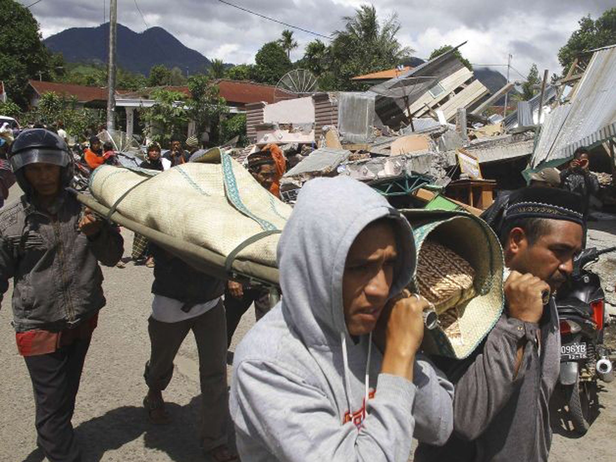 Residents carry the body of their relatives for funeral in Blang Mancung village after a 6.1 magnitude earthquake hit Aceh province