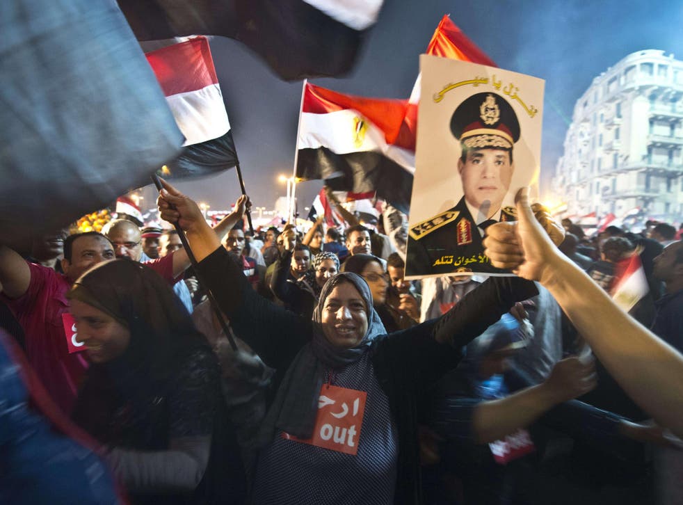 People celebrate at Tahrir Square with a portrait of Army chief Abdel Fattah al-Sisi after a broadcast confirming that the army will temporarily be taking over from the country's first democratically elected president Mohammed Morsi 