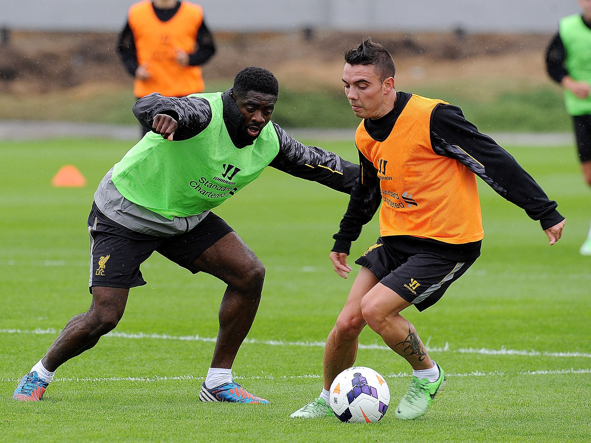 Kolo Toure and Iago Aspas of Liverpool in action during a training session at Melwood Training Ground