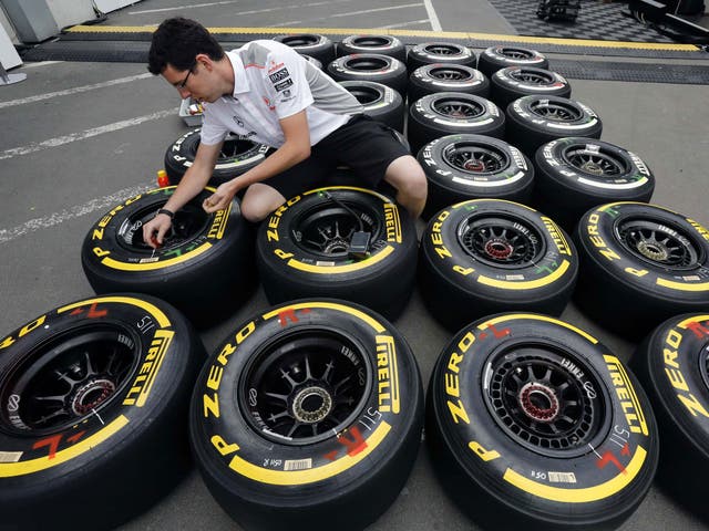 An engineer checks the new Kevlar-enforced rear tyres of McLaren drivers Sergio Perez and Jenson Button in preparation for the German Grand Prix at the Nürburgring