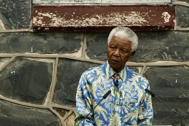 Nelson Mandela outside his former prison cell attends a press conference for "46664 - Give One Minute of Your Life to AIDS" on November 28, 2003