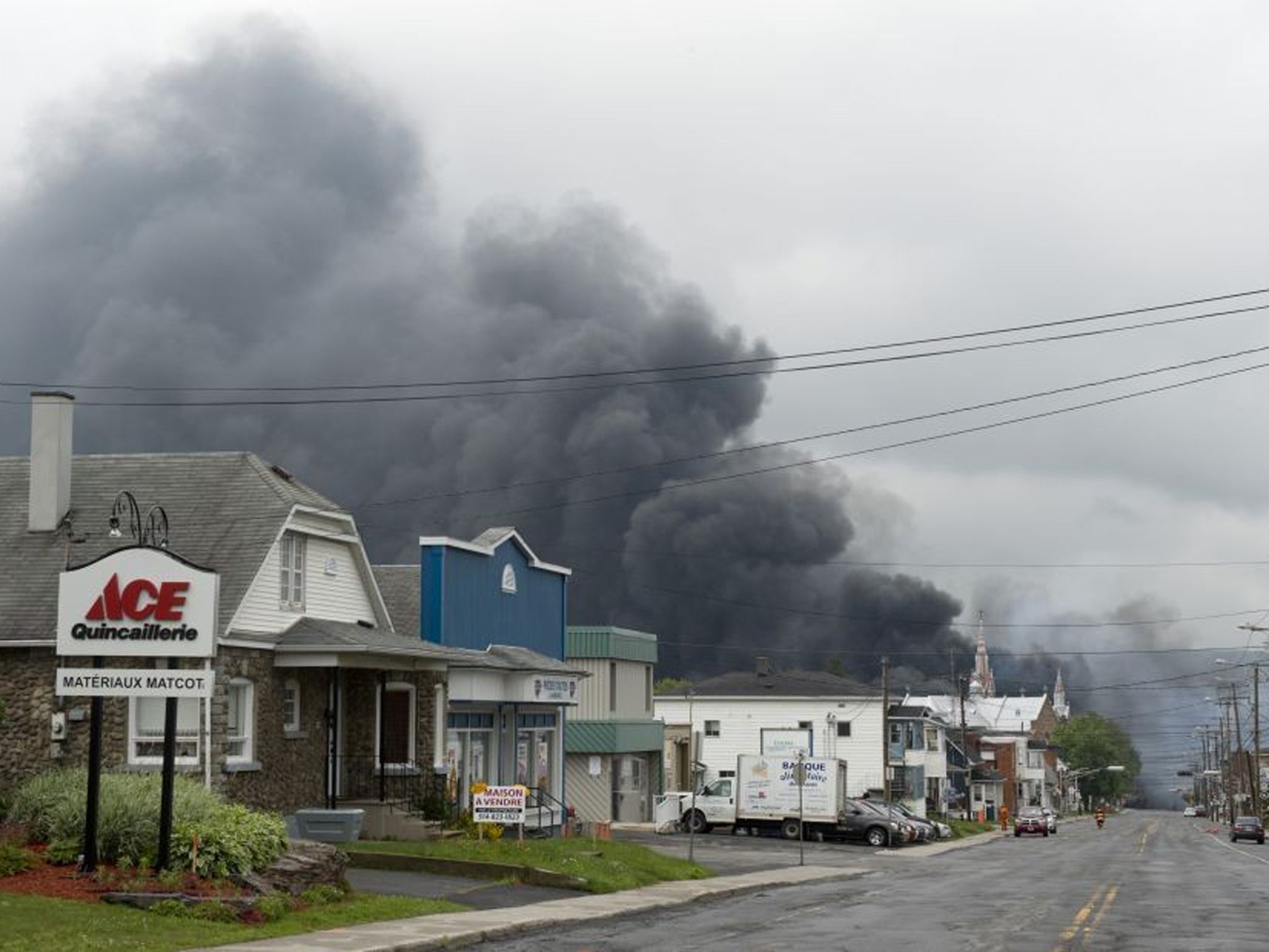 Smoke rises from railway cars that were carrying crude oil after derailing in downtown Lac Megantic, Quebec, Canada (AP)