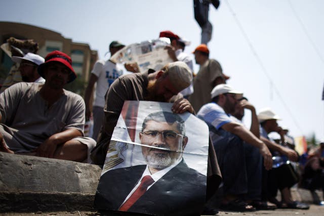 Lost leader: A supporter of the deposed President Morsi displays his image