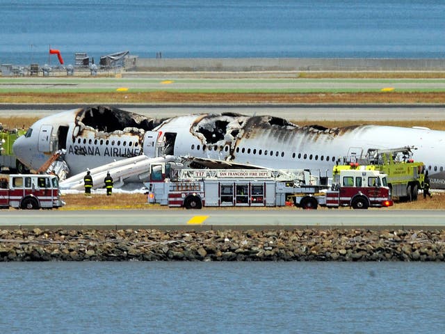 The Asiana Airlines Boeing 777 is seen on the runway at San Francisco International Airport after crash landing