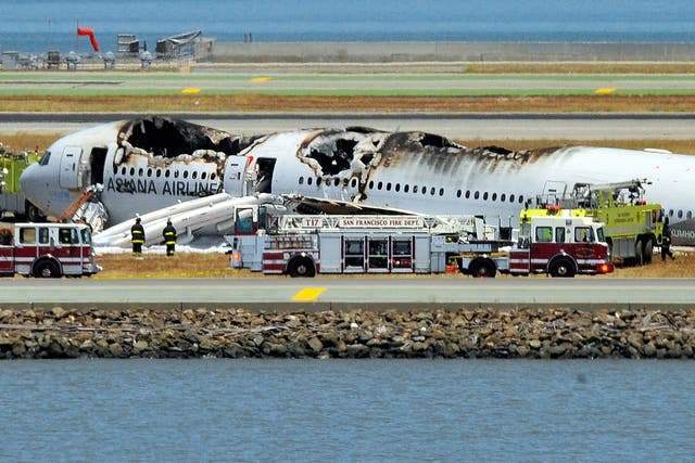 The Asiana Airlines Boeing 777 is seen on the runway at San Francisco International Airport after crash landing