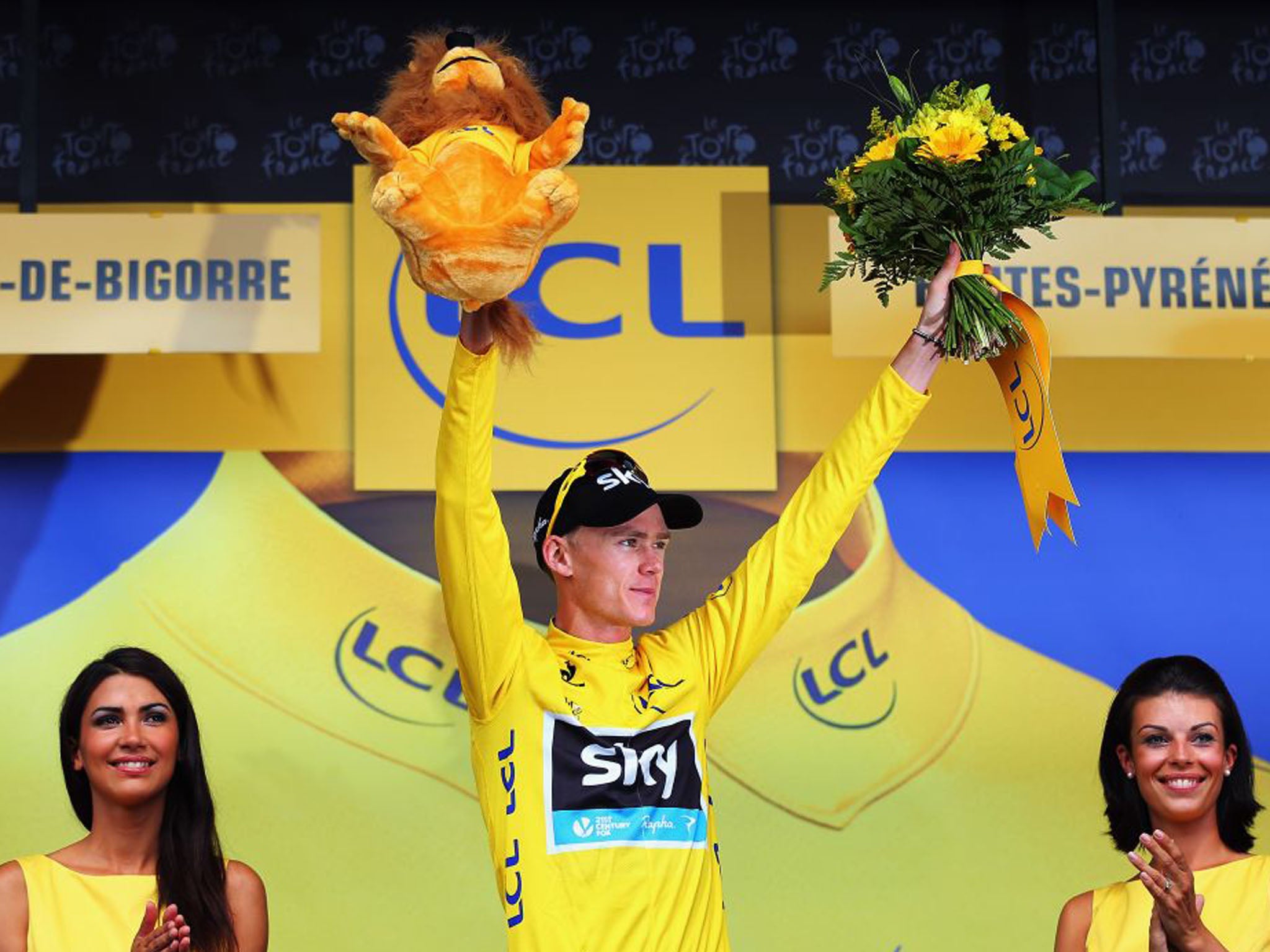 7 July 2013: Chris Froome of Britain steps onto the podium wearing the overall leader's yellow jersey after the ninth stage
