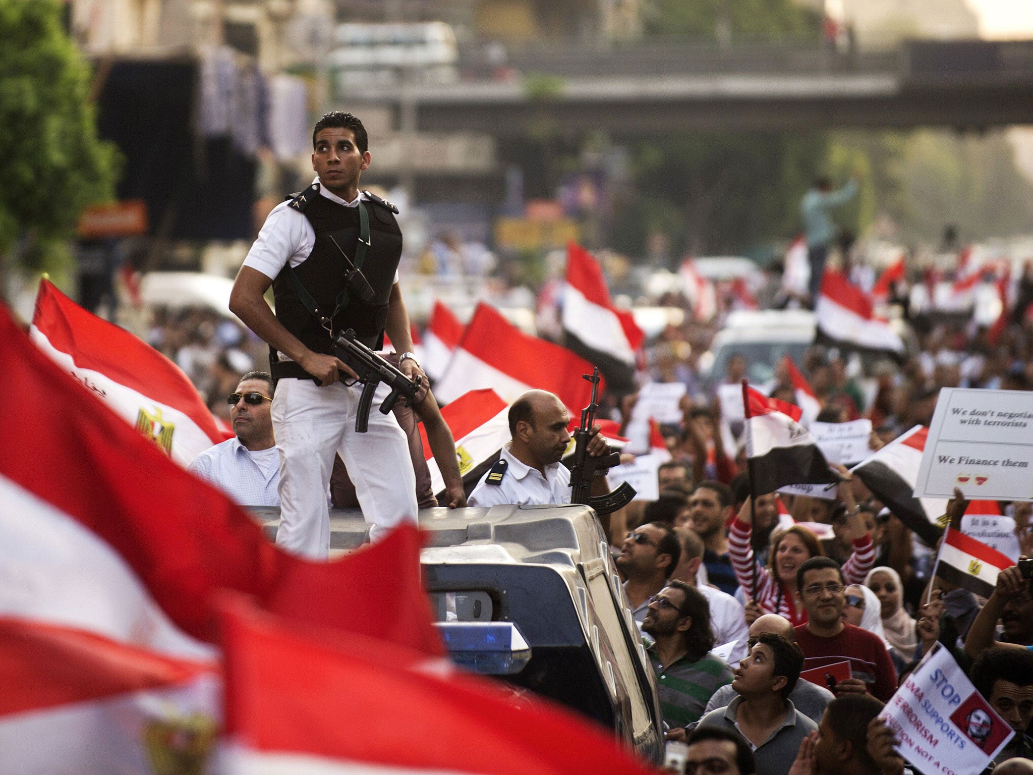 Policemen amid protesters demonstrating against the deposed President Mohammed Morsi