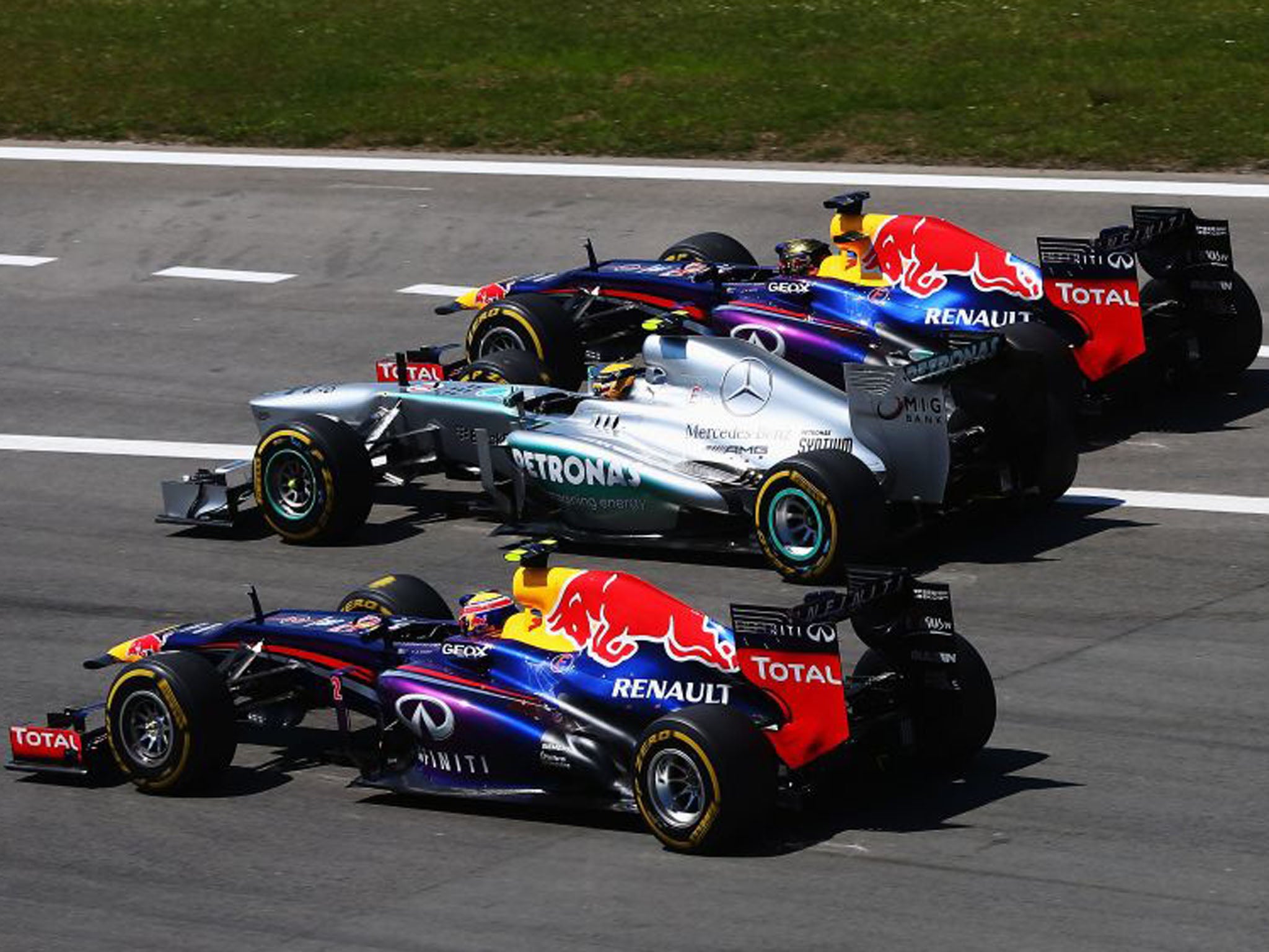 Lewis Hamilton, centre, was put under pressure by Sebastian Vettel, right, and Mark Webber, left, in the first corner and was pushed from first into third