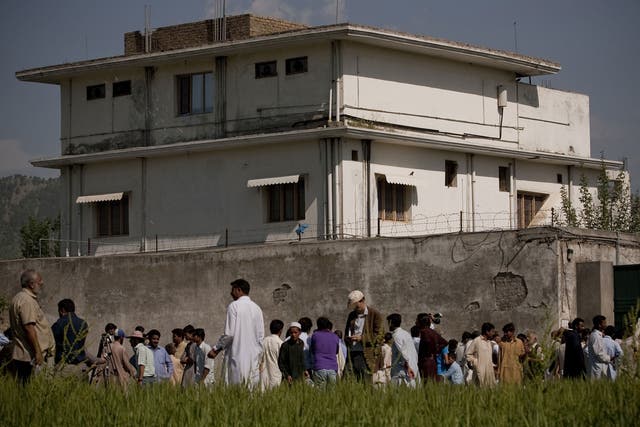 Locals and media gather outside the compound, pictured in May 2011, where Osama Bin Laden was reportedly killed in an operation by US Navy Seals