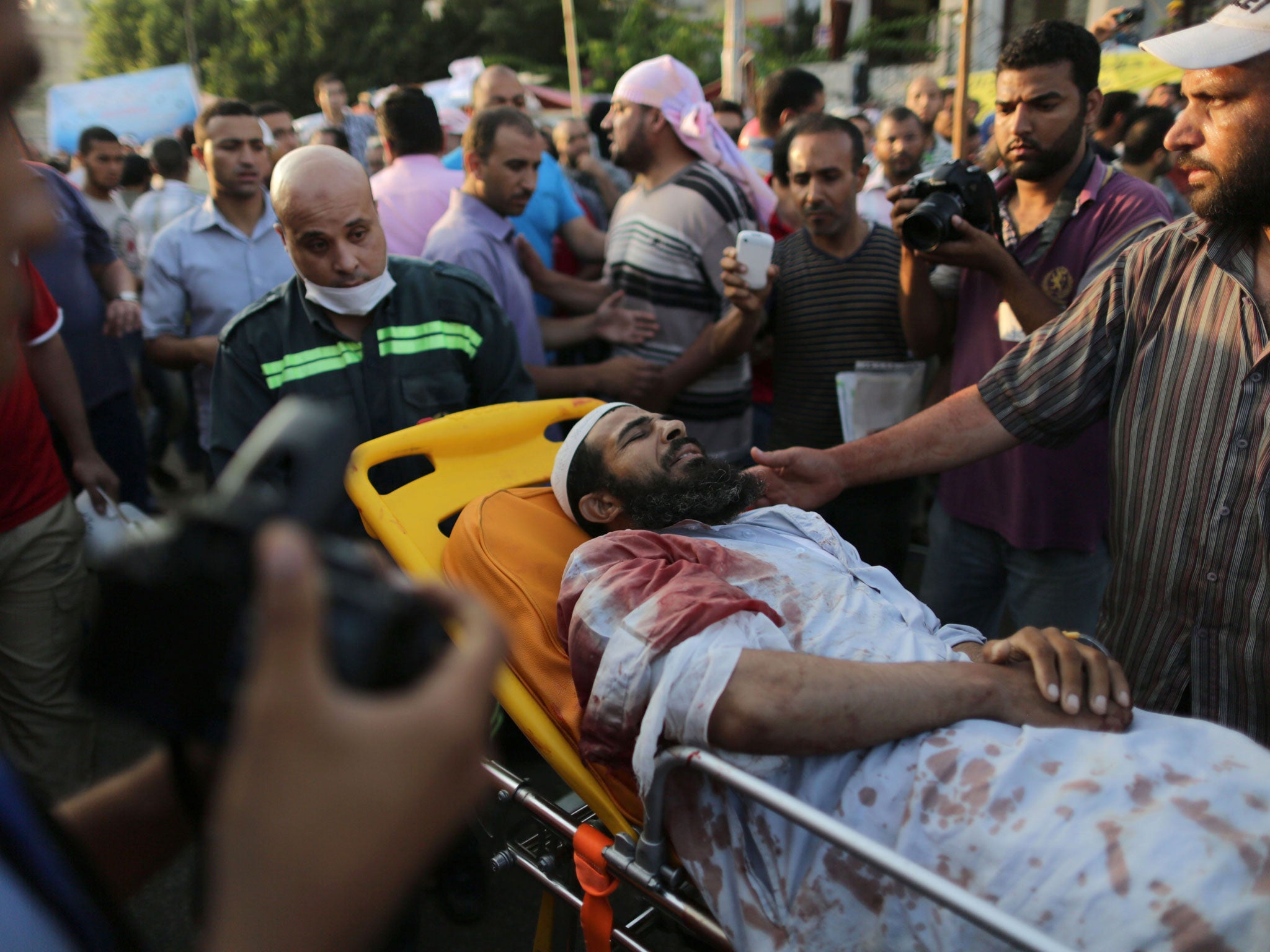 An injured man is brought to hospital for treatment following the shooting of Muslim Brotherhood supporters in Cairo