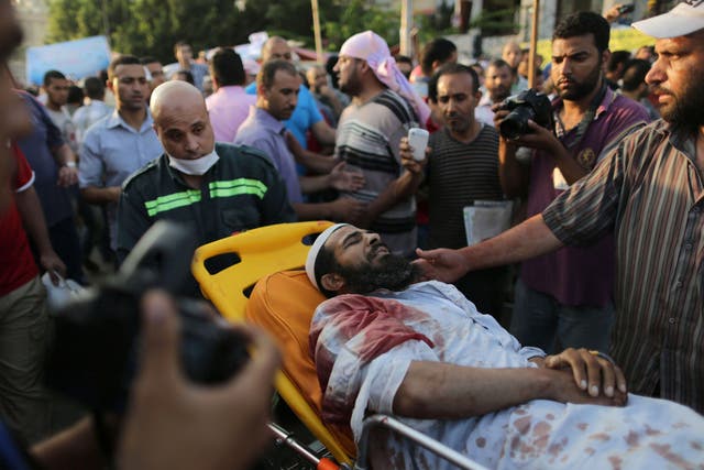 An injured man is brought to hospital for treatment following the shooting of Muslim Brotherhood supporters in Cairo