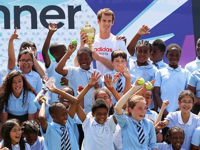 Andy Murray, holding the Wimbledon trophy, with a group of schoolchildren in London