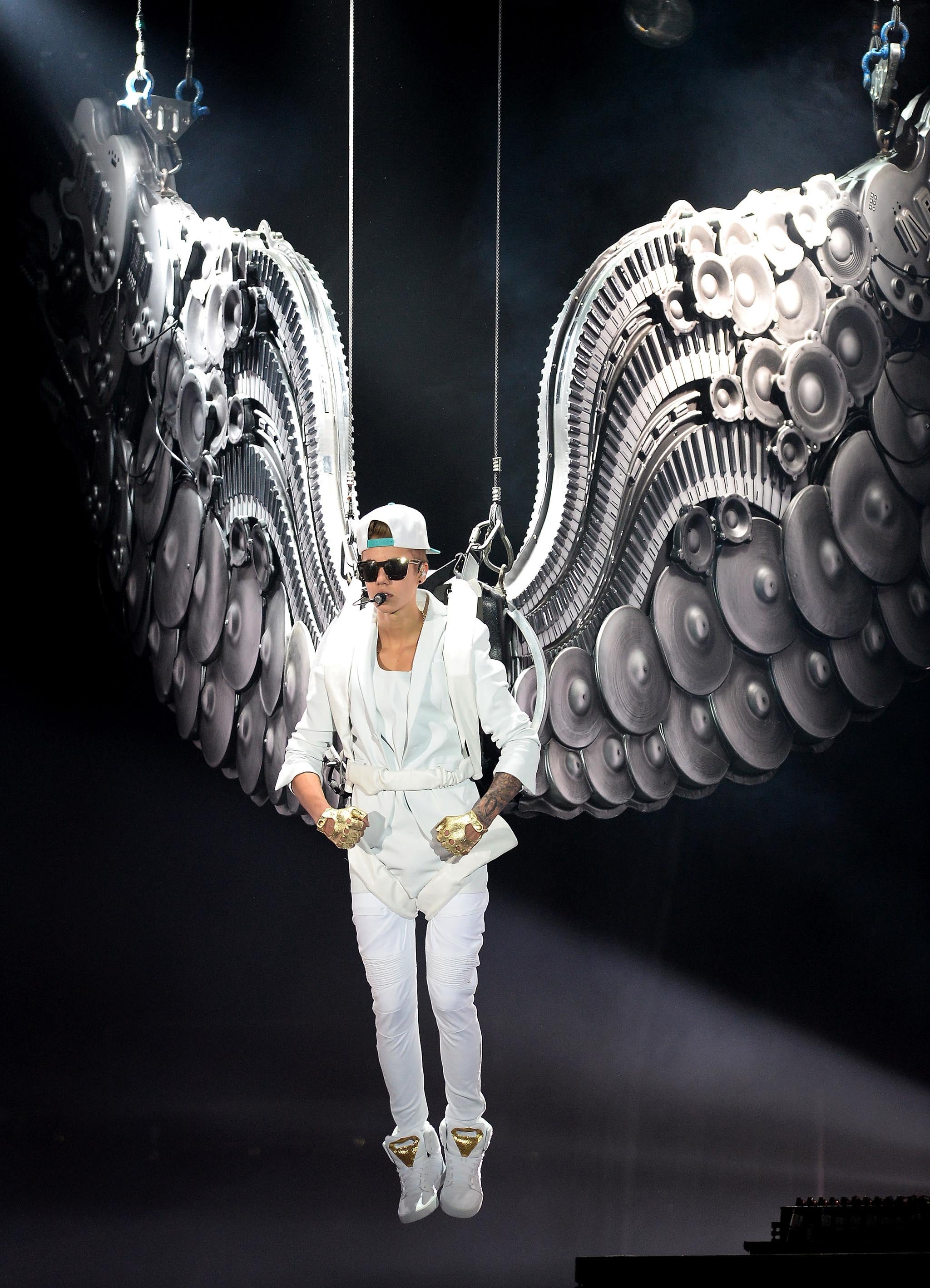 Justin Bieber appears suspended from the ceiling as an angel as part of his 'Believe' world tour