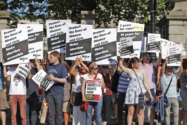 Pro-choice supporters hold placards in front of the Irish Parliament