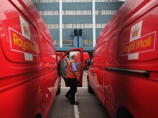 A Royal Mail employee steps out of a delivery van 