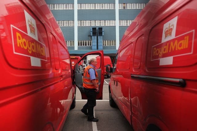 A Royal Mail employee steps out of a delivery van 