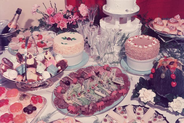 A table at a wedding reception laden with a garish variety of culinary delights, such as cold meats, salads, vol-au-vents and petit-fours.