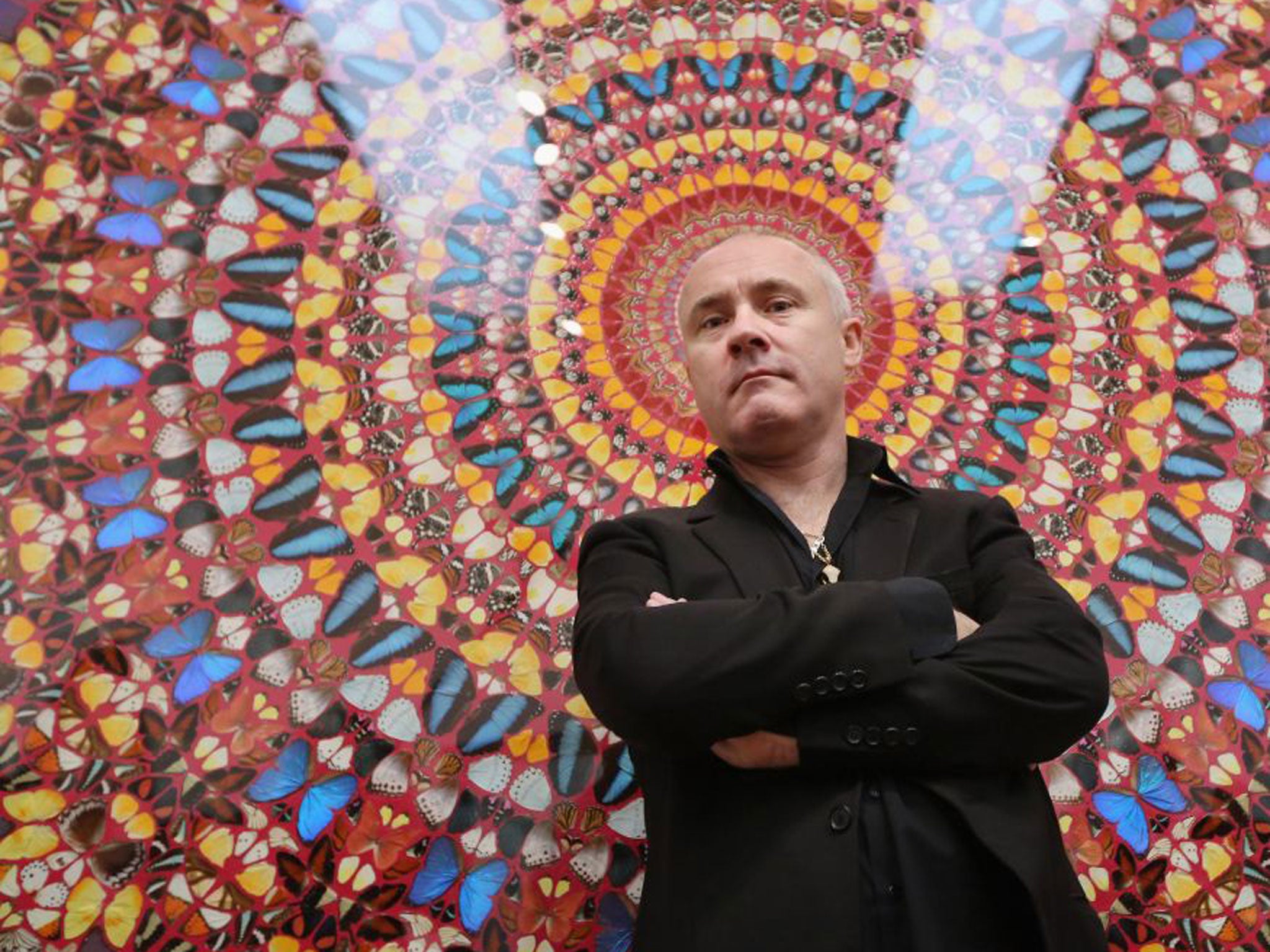 Artist Damien Hirst poses in front of his artwork entitled 'I am Become Death, Shatterer of Worlds' in the Tate Modern art gallery