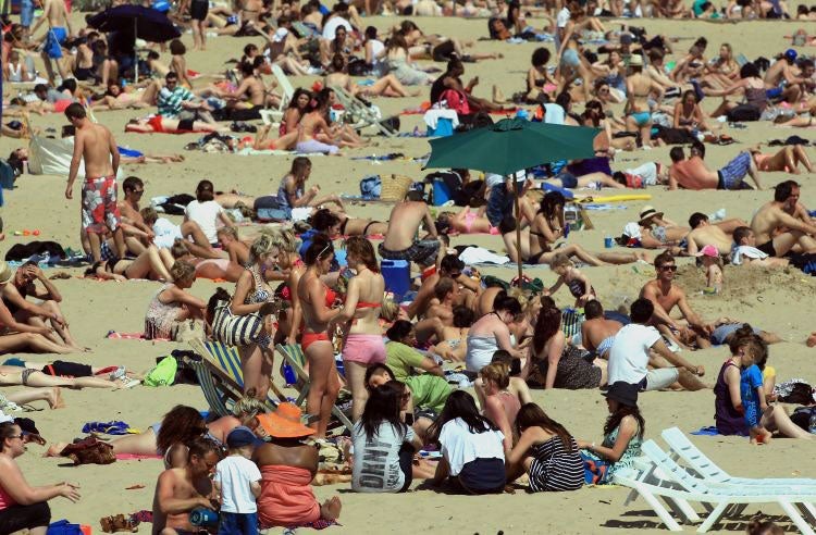 Sun worshipers head down to the beach on Saturday, the hottest day of 2013