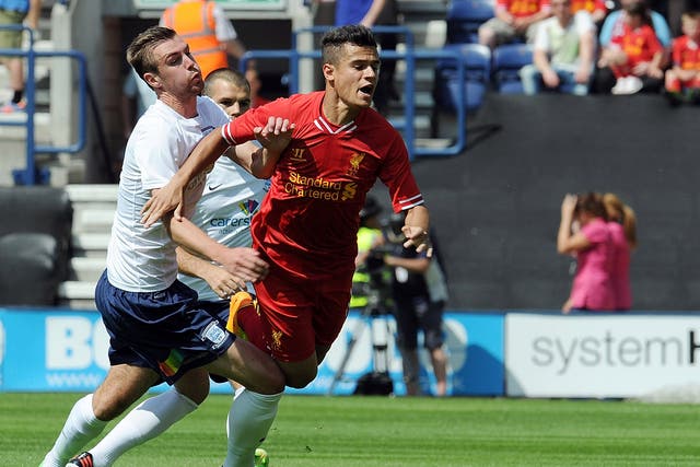 Philippe Coutinho of Liverpool is brought down by Paul Huntington of Preston North End during the Preston North End and Liverpool pre season friendly at Deepdale