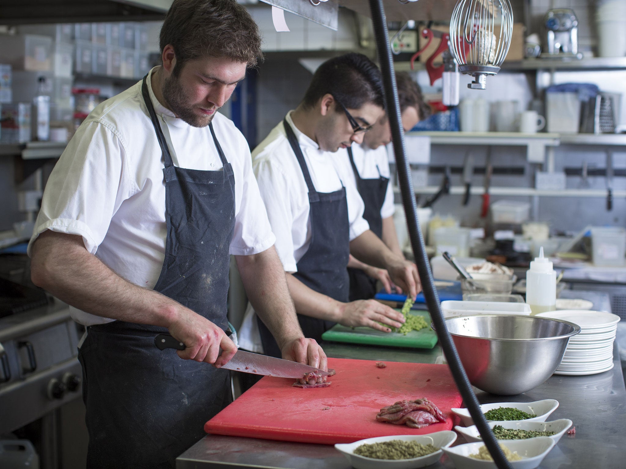 Chef Oliver Gladwin (left) and staff prepare food in The Shed. But restaurants are facing a staffing squeeze