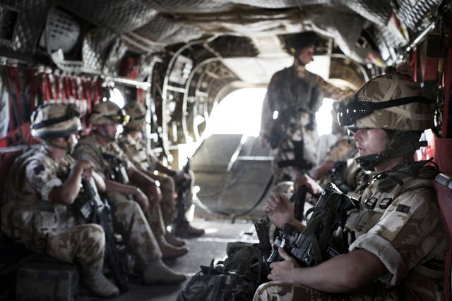 British Army soldiers from the Quick Reaction Force travel in the helicopter to protect the British Army Medical Emergency Response team from the UK Med Group as they go to the front line to collect a casualty on June 11, 2007