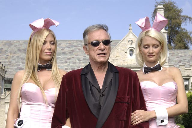  Playboy bunny Sheila Levell, Playboy founder Hugh Hefner and Playboy bunny Holly Madison perform a scene during the filming of a commercial for 'X Games IX' at the Playboy Mansion May 6, 2003 in Holmby Hills, California. 