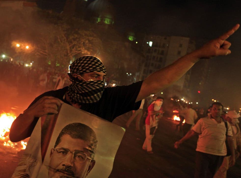 A Morsi support holds a poster of him during the clashes in Cairo last night
