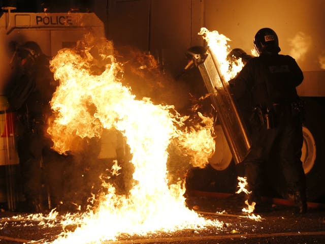 A petrol bomb hits riot police after being thrown by loyalist rioters in north Belfast, Northern Ireland
