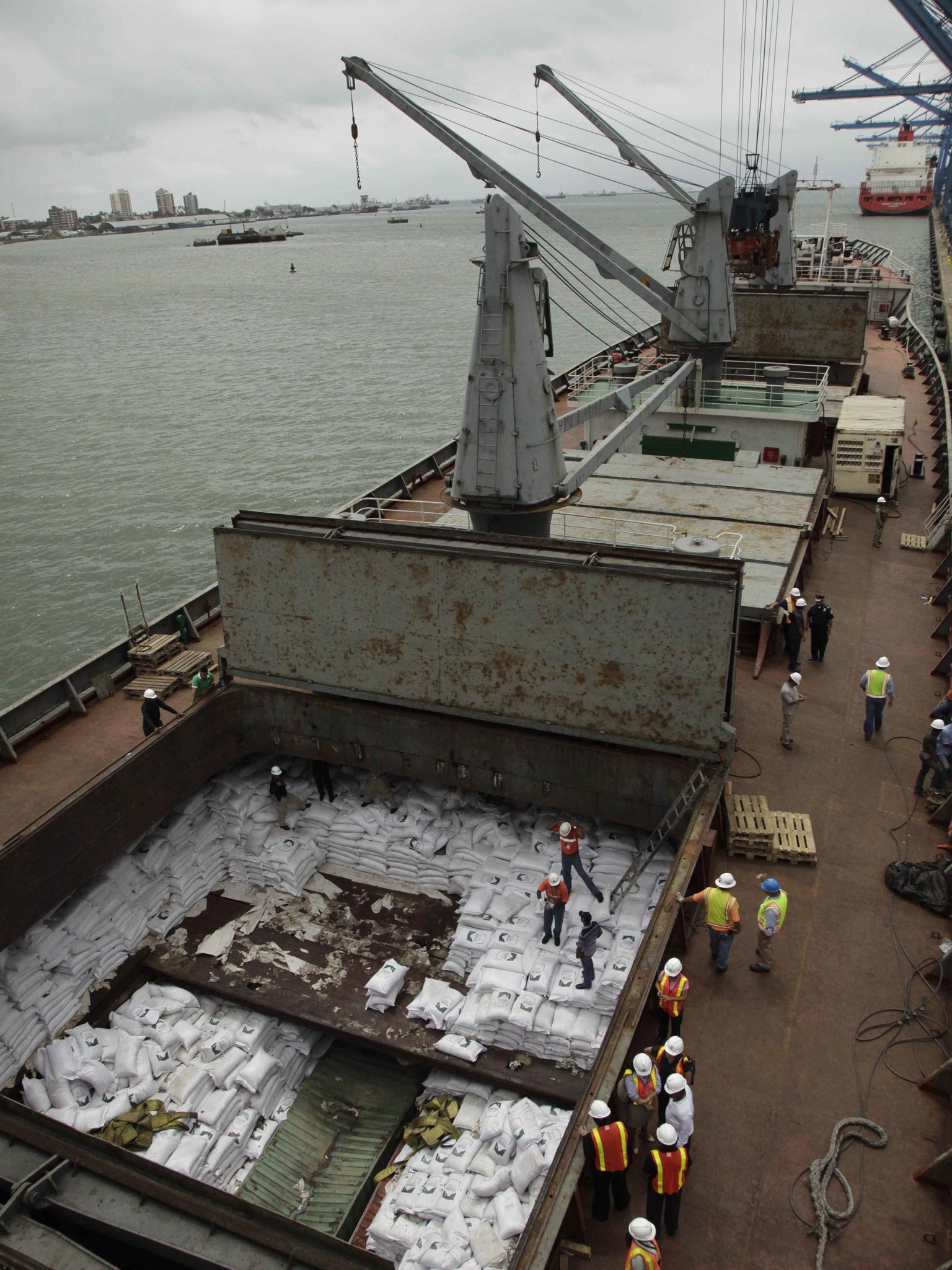 Panamanian workers stand on top of sacks of sugar inside a container aboard a North Korean-flagged ship at the Manzanillo International container terminal on the coast of Colon City, Panama