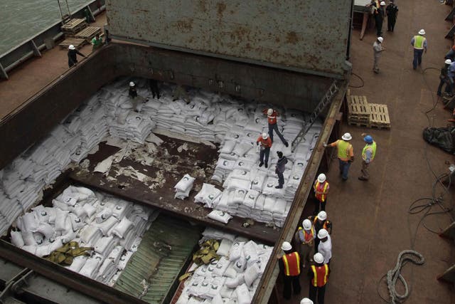 Panamanian workers stand on top of sacks of sugar inside a container aboard a North Korean-flagged ship at the Manzanillo International container terminal on the coast of Colon City, Panama