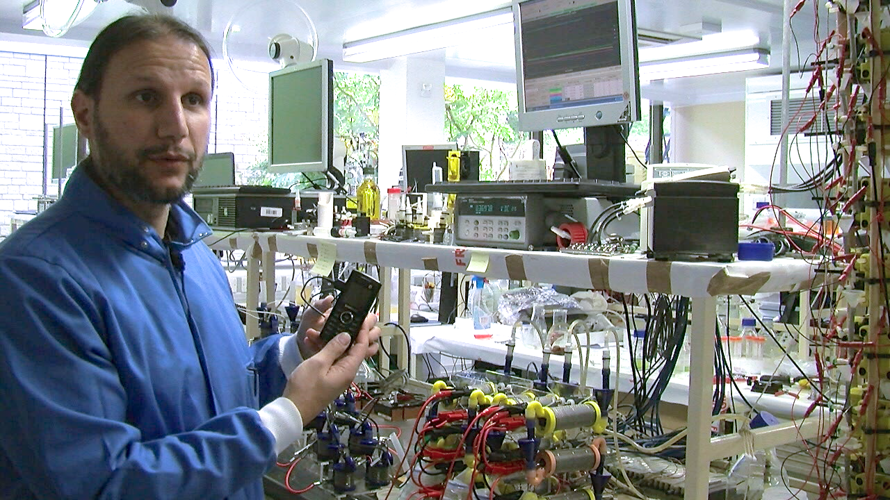 Dr Ioannis Ieropoulos inside the Bioenergy laboratory at the BRL, holding a phone powered by a microbial fuel cell stack.