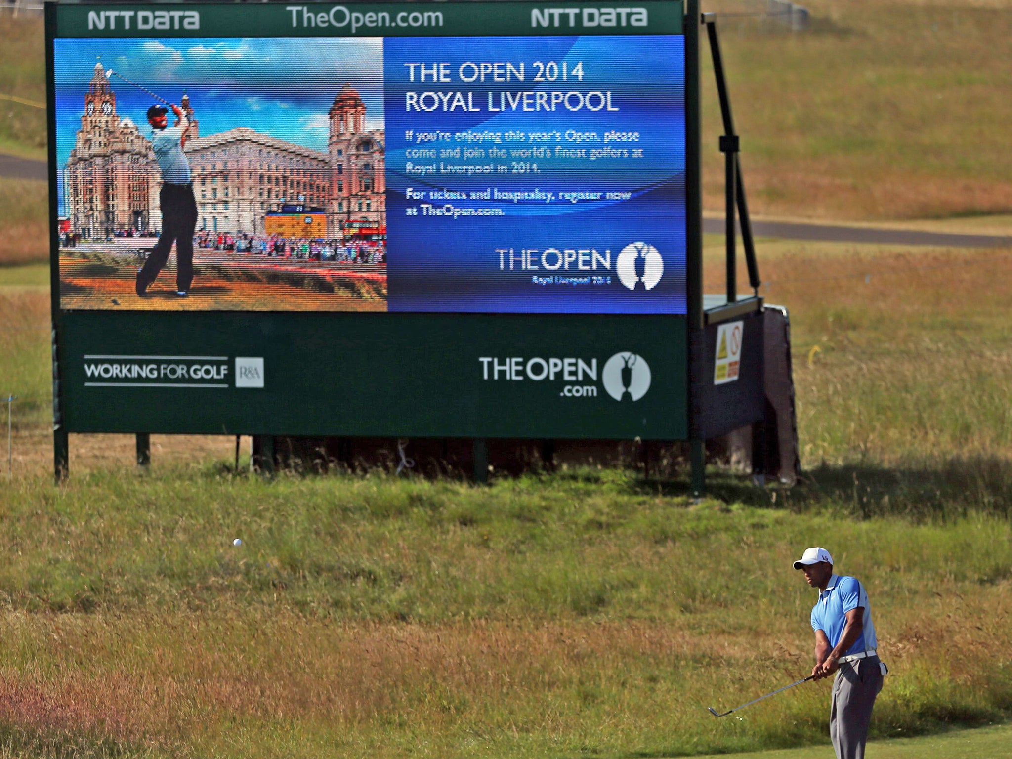 Seeing double: Tiger Woods appears on a screen advertising the 2014 championship while practicing for this year's event