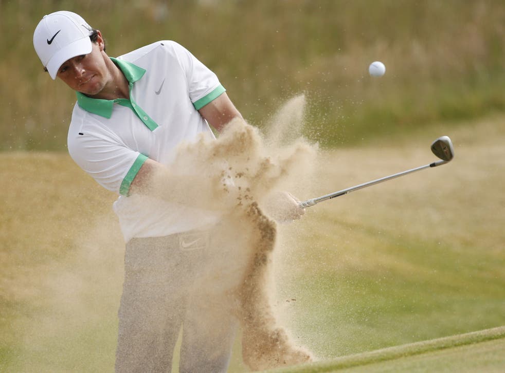 Rory McIlroy plays out of a bunker on to the first green yesterday