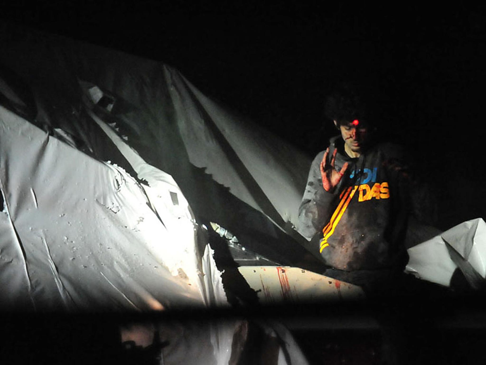 An injured Dzhokhar Tsarnaev emerges from the boat where he had been hiding - a sniper's red dot can be seen on his head