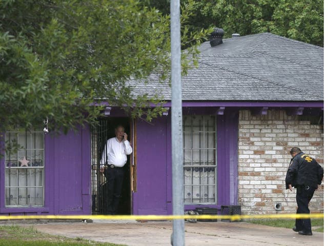 Authorities investigate a home on Friday after four homeless men were found in "deplorable" conditions