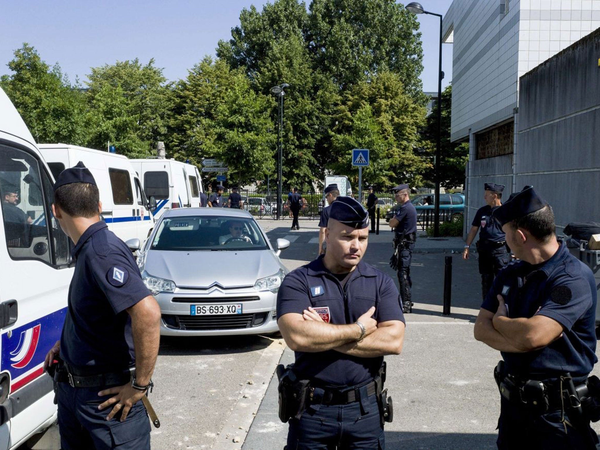 French police stand next to a police station in Paris after violent clashes erupted on Thursday