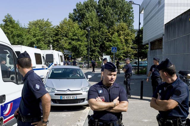 French police stand next to a police station in Paris after violent clashes erupted on Thursday