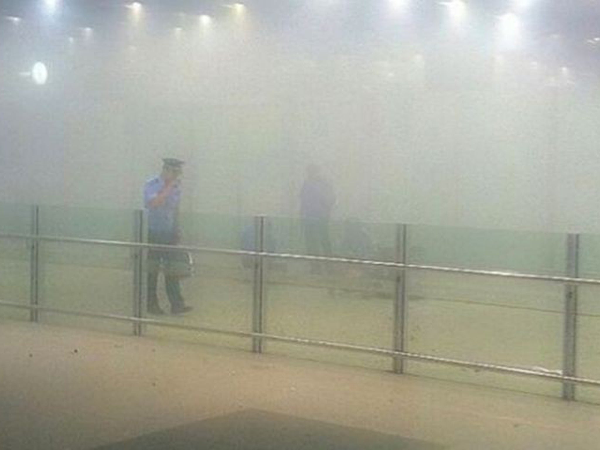 A policeman stands amid smoke Beijing Capital International Airport