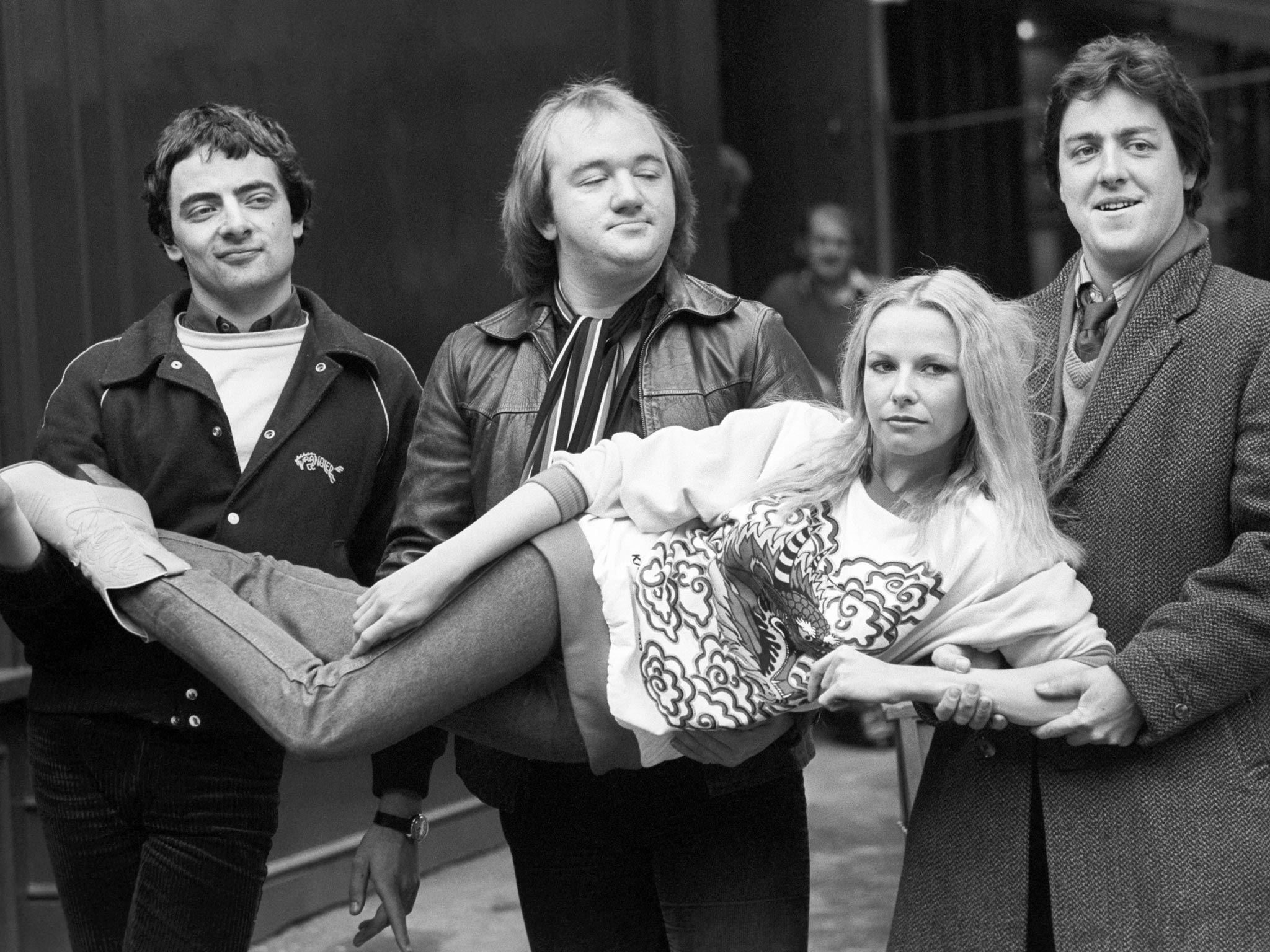 The 'Not the Nine O'Clock News's team (left to right), Rowan Atkinson, Mel Smith, and Griff Rhys Jones carrying Pamela Stephenson in 1980