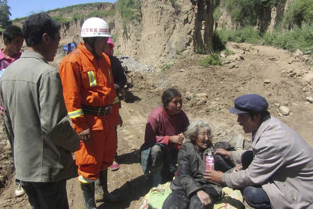 A man feeds water to an injured woman following the earthquake