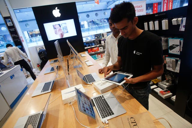 A salesperson unpacks an Apple iPad Mini to test it for a customer in the Apple specialty section of a Croma retail store in Mumbai February 22, 2013. . REUTERS/Vivek Prakash