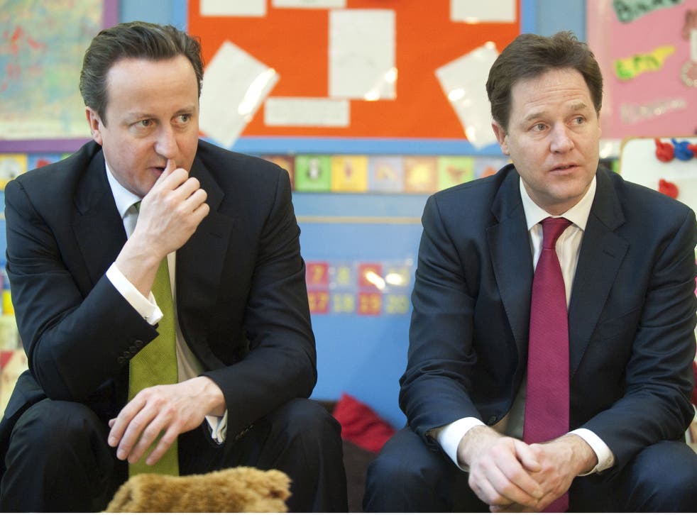 British Prime Minister David Cameron (L) and Deputy Prime Minister Nick Clegg (R) sit together as they visit the Wandsworth Day Nursery in London on March 19, 2013.