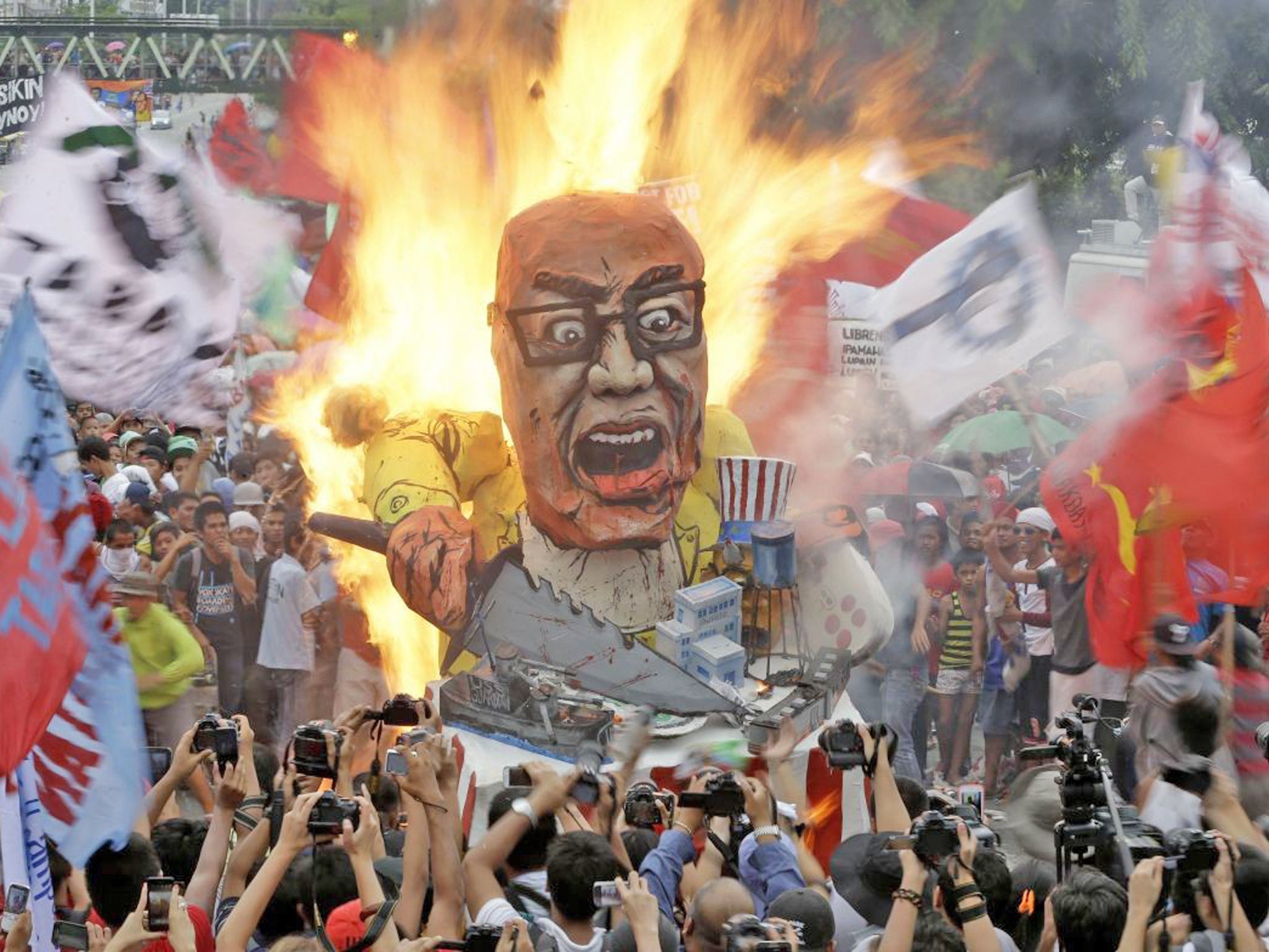 Protesters burn an effigy of the Philippine President Benigno Aquino III during
a rally in Quezon, northeast of Manila
