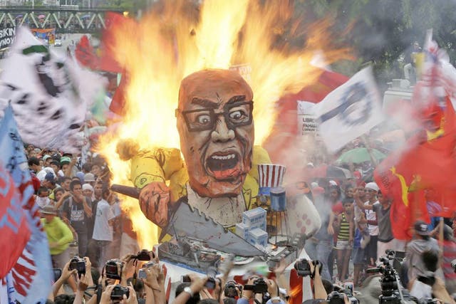 Protesters burn an effigy of the Philippine President Benigno Aquino III during
a rally in Quezon, northeast of Manila