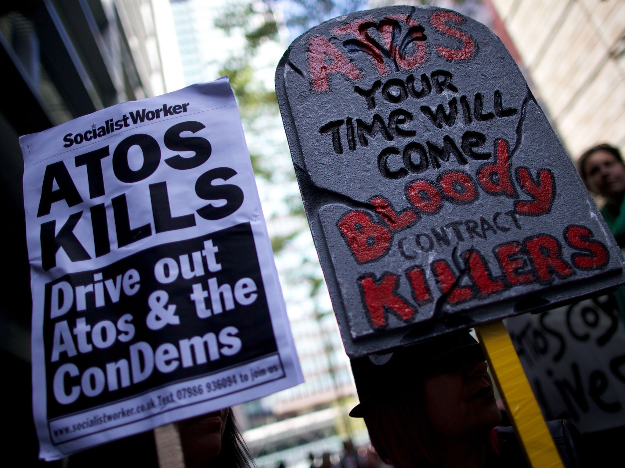 Protesters carry placards during a protest against Atos outside the company's head office in London last year