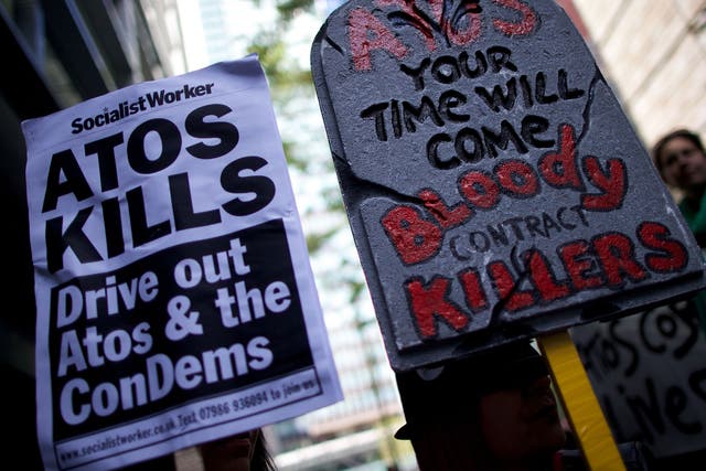 Protesters carry placards during a protest against Atos outside the company's head office in London last year