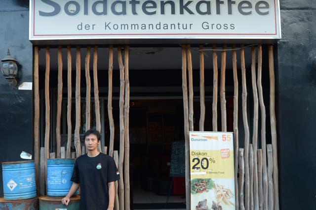 Henry Mulyana standing outside the Soldatenkaffe 'The Soldiers' Cafe' in Bandung